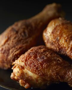 "Home cook attempting to replicate Willie Mae's chicken recipe in a kitchen setting."